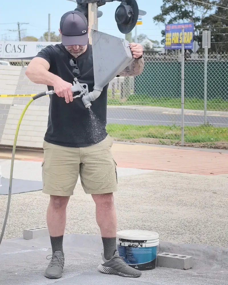 A student spraying fleck with a hopper gun at the workshop